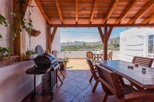 阿古伊梅斯MultiAventura en Agüimes的一个带桌椅和烧烤架的庭院