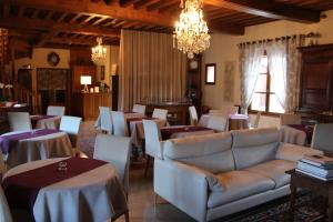 Curtil-VergyHotel Le Manasses的客厅配有桌子、沙发和椅子