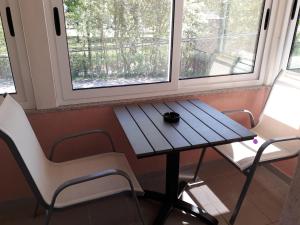 Dubrave GornjePrivate Home Rifat的窗前的一张桌子和两把椅子