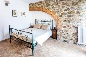 马萨马里蒂马Podere Vecchia Commenda的卧室配有一张石墙床