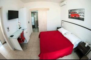 切萨雷奥港Exotic B&B的一间卧室配有红色的床和一张书桌