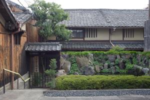 京都出水町家度假屋的一座带围栏的房屋前的花园