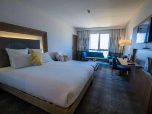 穆罕默迪耶Novotel Mohammedia的酒店客房设有一张大床和一张书桌。