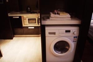 南京南京凯宾酒店公寓连锁新街口店的厨房配有洗衣机和微波炉。