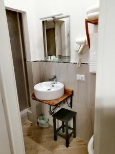 皮昂比诺Tre Orologi的一间带水槽和镜子的浴室