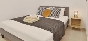雅典Phaedrus Living City Center Luxury Flat Skoufa的一间卧室配有一张大床和毛巾