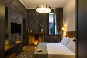 威尼斯Riva del Vin BOUTIQUE HOTEL的酒店客房配有一张床和一个壁炉。