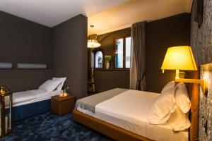 威尼斯Riva del Vin BOUTIQUE HOTEL的酒店客房,设有两张床和一盏灯