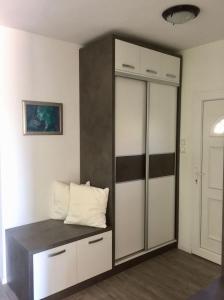 埃格尔Flair Apartmanház的一间房间,内配一个衣柜和枕头