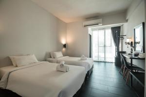 清迈iWualai Hotel的酒店客房配有两张床和一张书桌