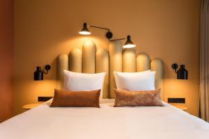 迪斯胡克Hotel Zeeuws Licht I Kloeg Collection的卧室配有一张带两个枕头的大白色床