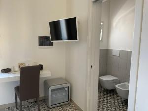 莱韦拉诺Casa Birra Salento的一间带卫生间的浴室和墙上的电视