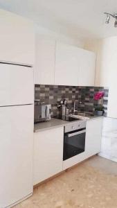 科拉雷侯Apartamento Ocean的白色的厨房设有水槽和炉灶。