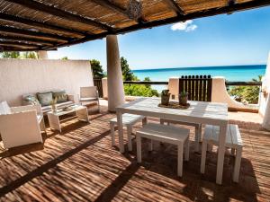 夏卡Villa Sciacca Lumia的海滩甲板上的白色桌椅