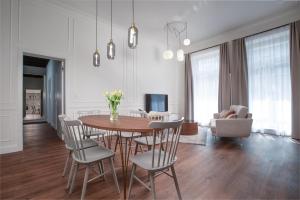 布拉格OREA Place Seno的用餐室以及带桌椅的起居室。