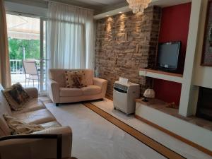 帕雷恩特西菲基昂Palio Villa的带沙发、电视和壁炉的客厅