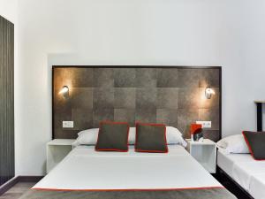 马德里Hello Feria的卧室配有一张带两个枕头的大白色床