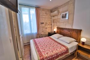阿尔勒Hôtel La Muette的一间卧室设有一张大床和一个窗户。
