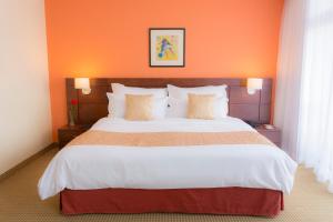 加拉加斯CONTINENTAL ALTAMIRA的一间卧室配有一张带橙色墙壁的大床