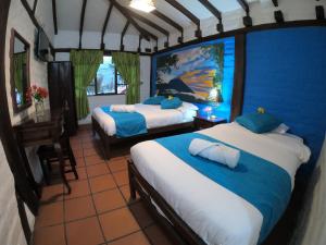 巴尼奥斯Hostal Inti Luna的一间卧室配有两张蓝色墙壁的床和一张桌子