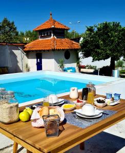 科英布拉Oryza Guest House& Suites的一张野餐桌,旁边是游泳池,上面有食物