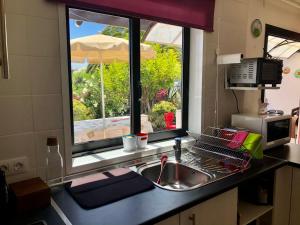 普拉亚布兰卡Casa Beatriz的带水槽的厨房台面和窗户