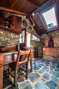 FrejulfeLa Casa de la Naturaleza的石屋设有木桌和长凳