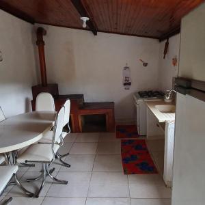 圣若泽-杜巴雷鲁CASA ACALANTA-Trilha das Flores-SERRA DA CANASTRA的厨房配有桌椅和炉灶。