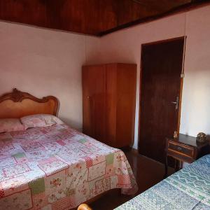 圣若泽-杜巴雷鲁CASA ACALANTA-Trilha das Flores-SERRA DA CANASTRA的一间卧室设有两张床,一扇门通往一个衣柜。