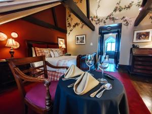 魁北克市勒克罗斯圣路易酒店的配有酒杯桌子和床的房间