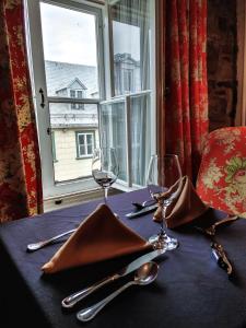 魁北克市勒克罗斯圣路易酒店的桌子上带酒杯和餐巾的桌子,带窗户