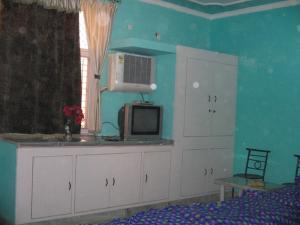 大诺伊达Balaji Guest House - Home Stay的一间卧室配有白色橱柜和电视机