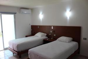 坎昆Hotel Casa Grande Cancun的酒店客房设有两张床和窗户。