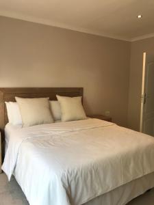 Mabalingwe Game ReservePafuri Gate Guesthouse的卧室配有一张带白色床单和枕头的大床。