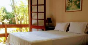 普拉杜古阿比巴宾馆的卧室配有白色的床和大窗户