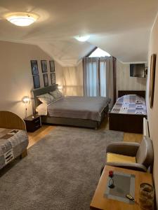 采蒂涅Apartments Aleksandra Cetinje的一间卧室配有一张床、一张沙发和一张桌子