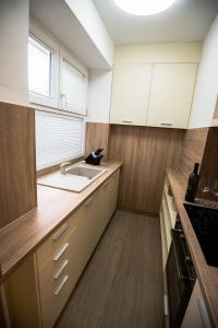 希贝尼克N & D的厨房配有白色橱柜和水槽