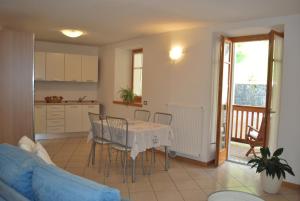 Castel CondinoCadari' Appartamenti的厨房以及带桌椅的起居室。