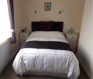 帕Penarth Guest House的一间卧室配有一张带白色床单的大床