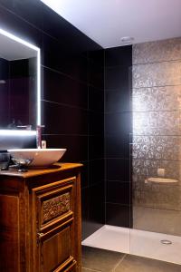 那慕尔里安乡村度假别墅酒店的浴室配有盥洗盆和带镜子的淋浴