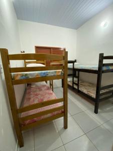 加利纽斯Casa em Galinhos/RN的客房设有三张双层床和一张桌子。