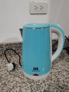 卡加盐德奥罗AFS Suites Barra, Opol的充电器柜台上的蓝咖啡杯