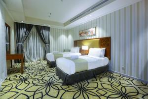 吉达Lotaz Hotel Suites - Al Salamah的酒店客房设有两张床和钢琴