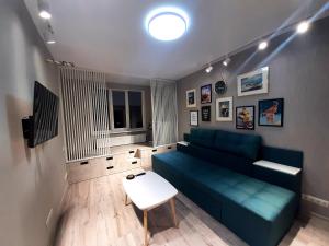 伊尔平Relax Point Plus Apartment的客厅配有蓝色的沙发和桌子