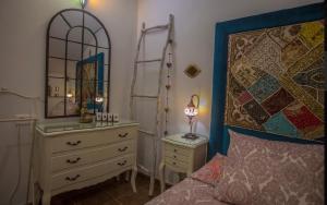 隆达布达郎奇公寓的一间卧室配有一张床、梳妆台和镜子