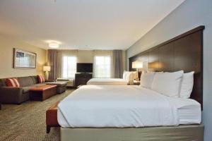 奥斯汀Staybridge Suites Austin South Interstate Hwy 35, an IHG Hotel的酒店客房设有一张大床和一张沙发。