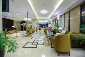 吉达Lotaz Hotel Suites - Al Salamah的两人坐在酒店的大堂