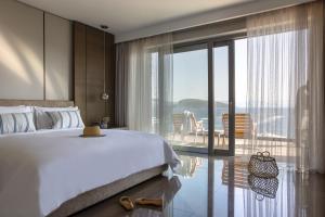 博德鲁姆METT Hotel & Beach Resort Bodrum的一间带大床的卧室和一个阳台