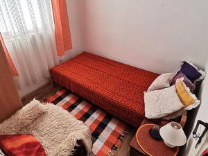 Rogljevo"Pivnica i smestaj Jovanovic"- Rogljevacke pivnice的一间小卧室,配有一张带红色棉被的床
