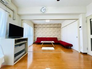 札幌札幌中心 ｻｰﾋﾞｽｱﾊﾟｰﾄﾒﾝﾄSapporo中島公園2LDK 901的客厅配有红色的沙发和桌子